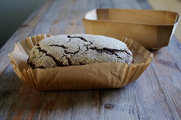 Image showing loaf of fresh rye bread in baking paper