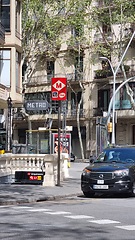 Image showing BARCELONA, SPAIN - APRILL 4, 2024: Black taxi car driving along tall buildings