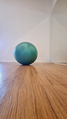 Image showing Green exercise ball on wooden floor in modern interior