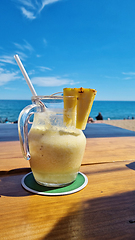 Image showing Pitcher of liquid on wooden table