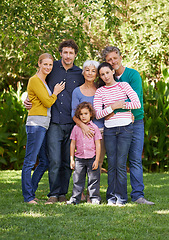 Image showing Family, portrait and hug in outdoor park, love and bonding together or happy in backyard. Generations, smile and peace or embrace for support in garden or care, vacation and summer holiday in France