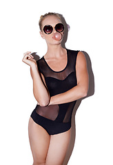 Image showing Sunglasses, fashion and woman with bubblegum in studio isolated on a white background. Confidence, portrait and person blowing gum or candy with stylish model in leotard on a backdrop in Switzerland