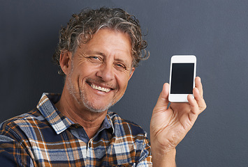 Image showing Man, portrait and cellphone screen in studio for website communication, grey background or connectivity. Male person, face and smile with smartphone for online internet, advertising or mockup space