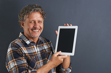 Image showing Tablet, screen and portrait of mature man in studio and learning about technology on dark background. Advertising, tech and mockup with post online to social media and person search internet for news