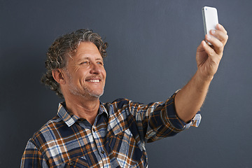 Image showing Mature, man and happy selfie in studio and learning about photography on dark background. Filming, video or click record for profile picture and post online to social media with website or blog