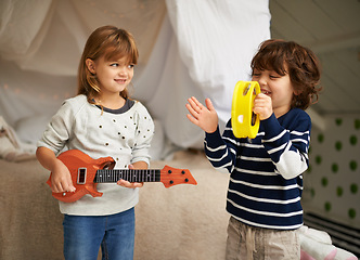 Image showing Music, playing and children with instruments in bedroom for fun, bonding and band practice. Happy, smile and young girl and boy kids with guitar and tambourine toys enjoying musical song at home.