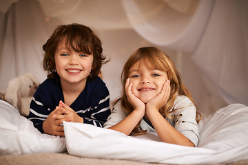 Image showing Smile, blanket fort and portrait of children relaxing, bonding and playing together at home. Happy, cute and young girl and boy kid siblings laying in tent for fun sleepover in bedroom at house.