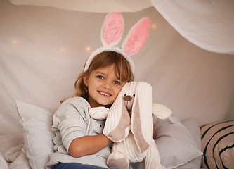 Image showing Girl, kid and bunny ears with teddy bear, soft toys and playing in fort for camping and fun at family home. Happiness, innocent and child with stuffed animal, games for Easter and fun in childhood