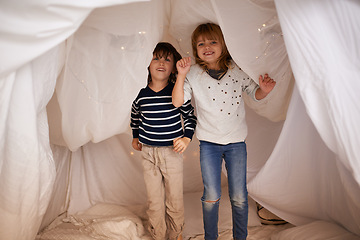 Image showing Happy, blanket fort and portrait of children standing, bonding and playing together at home. Smile, cute and young girl and boy kid siblings jumping in tent for fun sleepover in bedroom at house.