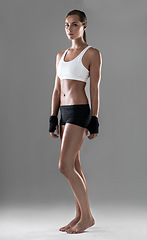 Image showing Woman, six pack with body and kickboxing for exercise, strong with muscle and sweat from workout on grey background. Boxing, self defense training and athlete for sports, fitness and power in studio