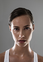 Image showing Woman, serious face and confident for fitness, strong and determined with sweat from workout on grey background. Headshot, portrait and athlete for sports, exercise with pride and power in studio