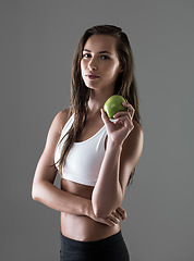 Image showing Portrait, apple and woman with nutrition, fitness and wellness on a grey studio background. Face, person and model with fruit and gut health with diet plan and balance with benefits and digestion