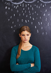 Image showing Rain, sad and woman with cloud on chalkboard for depression, unhappy and upset mood. Storm, winter weather and person with crossed arms for attitude, emotion and worry expression on dark background