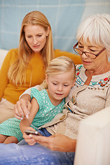 Image showing Girl, phone and social media at a home with grandmother, family and mother together with game. Learning, online and senior woman with child and mom with love, support and care in a house with tech