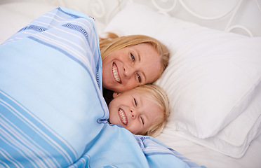 Image showing Home, mom and girl with lying in bed together to smile for bonding, relax and chill on break. Parent, kid and happy in bedroom to cuddle with blanket for joy, fun and child development or growth.