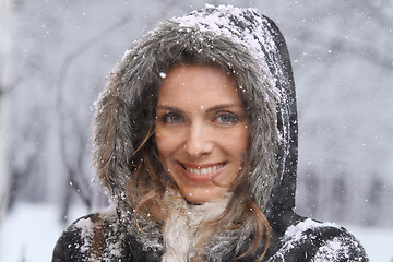 Image showing Woman, portrait and nature with snow, winter season with fur coat for fashion, good mood and outdoor in forest. Peace, calm and cold with comfort in jacket for weather, ice or frozen with travel
