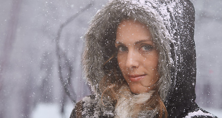 Image showing Snow, woman and travel with portrait outdoor in winter with storm, ice and holiday with jacket for climate. Cool, frost and female person in Iceland with adventure and freezing from weather in nature