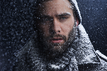 Image showing Snow, night and man with serious portrait outdoor in winter with storm, ice and travel with cold climate. Cool, frost and male person in Iceland with adventure and freezing from weather in nature