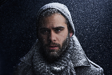 Image showing Snow, night and man with portrait outdoor in winter with storm, ice and travel with fashion for cold climate. Cool, frost and male person in Iceland with adventure and freezing from weather in nature