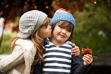 Image showing Kids, love and siblings kiss in a park for travel, adventure or bonding on autumn journey in nature. Family, support and children hug in a forest for explore, playing or fun games in Canada outdoor