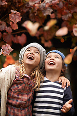 Image showing Happy, celebration and children with autumn leaves, freedom or fun in a park for bonding, games or playing. Nature, love and kids excited for tree confetti in woods for camping, learning or travel