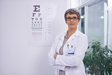 Image showing Letter, chart and woman with optometrist for eye exam, arms crossed with confidence and senior doctor at clinic. Alphabet, glasses for vision and prescription lens with assessment and ophthalmology