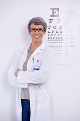 Image showing Mature woman, optometrist and arms crossed for eye care in portrait, test and alphabet chart for vision. Glasses, prescription lens and frame for healthcare, confidence with ophthalmologist at clinic