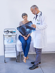 Image showing Hospital, consulting and doctor with x ray for patient for results, medical scan and treatment. Healthcare, clinic and senior person in consultation for wellness service, examination and diagnosis
