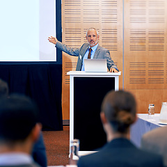 Image showing Senior, businessman and speaker with laptop for presentation, meeting or seminar on projector at office conference. Man, CEO or leader talking on podium to group or corporate audience at workshop