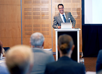 Image showing Businessman, presentation and conference with laptop for team meeting, staff training or seminar at the office. Man, employee or speaker talking with smile on podium for company or business workshop