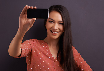 Image showing Woman, selfie and social media for online connection on studio for profile picture, technology or grey background. Female person, smiling and internet communication for update post, vlog or mockup