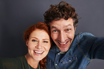 Image showing Love, selfie and happy couple in studio together with relationship trust, care and support. Photography, man and woman smile on dark background with commitment, loyalty and affection in marriage