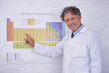 Image showing Laboratory, periodic table and portrait of scientist with research, teaching and smile in classroom. Science, education and professor man pointing at chemical elements on poster at lecture for study