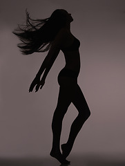 Image showing Dancer, woman and silhouette with shadow figure, body care and sensual on a dark studio background. Person, profile and model with beauty and seductive with wellness and natural pose with slim girl