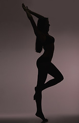 Image showing Slim girl, woman and silhouette with beauty, body care and sensual on a dark studio background. Person, profile and model with shadow figure and seductive with stretching and natural pose with dancer