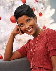 Image showing Happy, christmas and portrait of woman at her home for festive event, party or celebration. Smile, holidays and face of female person from Colombia with xmas tree on sofa in living room at apartment.