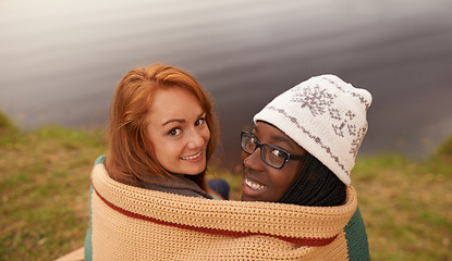 Image showing Camping, blanket and portrait of women by lake in nature on outdoor holiday, vacation and adventure, Campsite, travel and friends hug and bonding in woods, forest and countryside together in winter