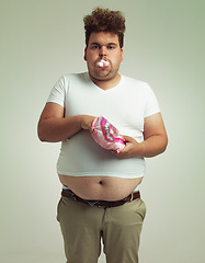 Image showing Food, portrait and plus size man with marshmallow, dessert and candy in a studio. Bag, sweet and unhealthy snack for over eating a treat with funny face and hungry male person with grey background