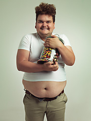 Image showing Candy, crazy and portrait of plus size man in studio for luxury snacks, sweets and dessert in container. Comic, funny facial expression and isolated person with glass for unhealthy diet on background