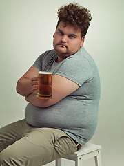 Image showing Portrait, arms crossed and plus size man with alcohol for unhealthy habit, serious and weight gain in studio of white background. Face, beer and male person by drink for stomach, calories and carbs