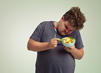 Image showing Bowl, man and thinking with salad in studio for healthy diet, weight loss and examine food. Plus size, male person and contemplating with organic meal for detox, lifestyle change and nutrition