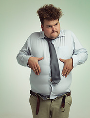Image showing Man, stomach and plus size with belly from unhealthy diet or weight gain on a studio background. Young male person or big guy holding tummy for eating disorder or body conscious on mockup space