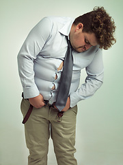 Image showing Plus size, fitting and man unhappy with pants, shirt and professional clothes or suit for work. Adult, guy and male person with stomach or belly, upset and feeling frustrated with outfit for job