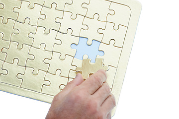 Image showing Person, hands and puzzle with piece for problem solving, solution or building on a white studio background. Closeup of creative with jigsaw board for thinking, development or matching on mockup space