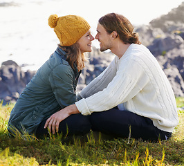 Image showing Happy, couple and together in nature or sitting on grass, hilltop and scenery or people looking with love. Care, smile and romantic date on winter vacation, holiday and relationship in Sweden