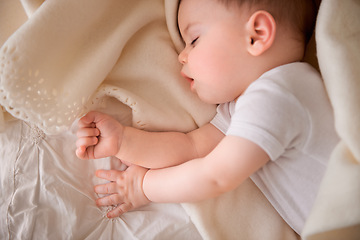 Image showing Baby, sleeping and tired at home with relax, nap and nursery with peace in a bed with blanket. Morning, youth and kid with dream of an infant with child development from rest in bedroom with newborn