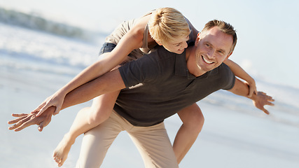 Image showing Couple, love and smile on beach with piggyback for bonding, honeymoon date and weekend holiday. Face, man and woman with embrace, happy and care in California by sea for vacation, travel or adventure
