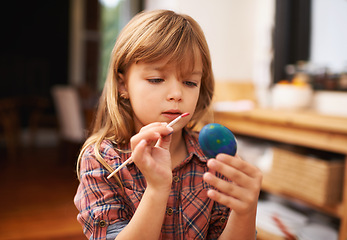 Image showing Happy girl, creative and color painting of egg, fun and celebration of easter holiday in home. Young, artist and girl with inspiration for learning craft, mural and watercolor for artwork in kitchen