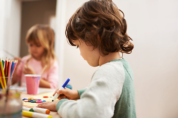 Image showing Child, writing and drawing with colorful art at home for learning, education or creativity. Young boy with color pencil for sketching, activity or artwork in early childhood development at the house