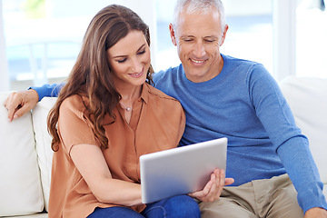 Image showing Couple, tablet and smile on sofa to relax with reading, search and app to watch movie with bonding. People, woman and mature man on digital touchscreen for notification with web connection in house